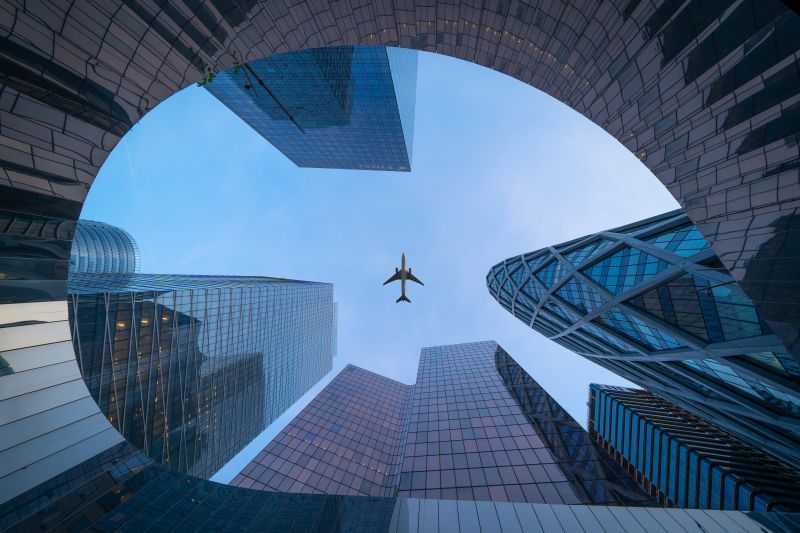 airplane flying over the building during daytime.jpg